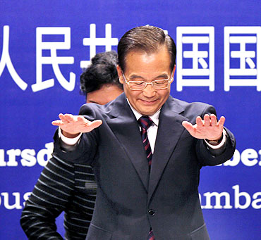 Chinese Premier Wen Jiabao gestures before taking his seat at an event