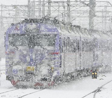 A commuter train travels into Malmo central railway station during heavy snow