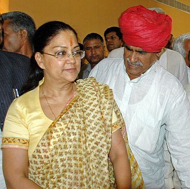 Former Rajasthan CM Vasundhara Raje and Gujjar leader Kirori Bainsla walk back after news conference in Jaipur