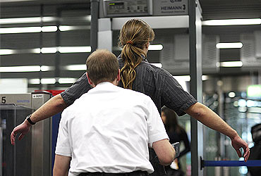 A passenger is checked by security personnel at the main terminal of Frankfurt's airport