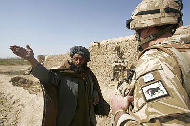 Colonel Matt Beazeley of the 28th Royal Engineer Regiment talks to a local Afghan farmer