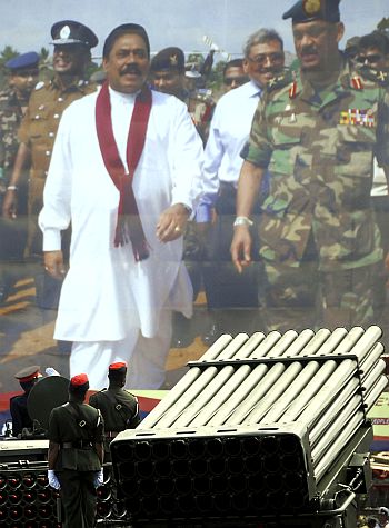 Sri Lankan army troops move past the portrait of President Mahinda Rajapakse and then Army Chief Sarath Fonseka during the National Victory Ceremony in Colombo June 3