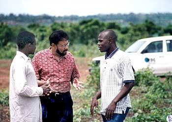 Dr Roy discusses planting with a farmer (left) and IFDC staffer in Togo