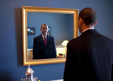 Obama looks at his appearance in the mirror