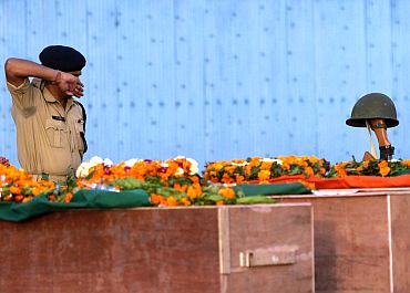 A CRPF jawan pays his last respects near the coffins of his colleagues who died in a Maoist attack in Chattisgarh