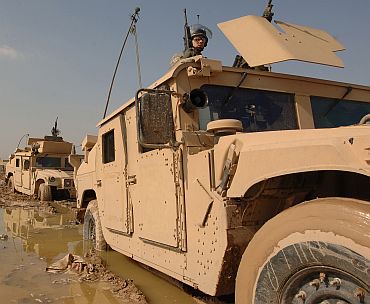 US Army soldiers maneuver their Humvees through the mud during a convoy patrol