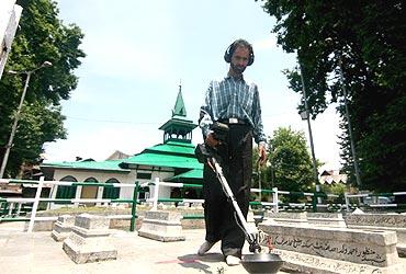 A security personnel examines for any possible explosives at the martyr's graveyard