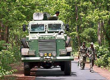 Paramilitary soldiers patrol with an anti-landmine vehicle
