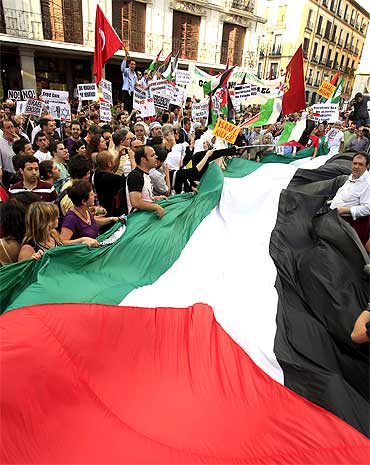 Demonstrators hold a Palestinian flag during an anti-Israel protest in front of the foreign ministry in Madrid