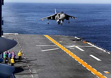A US Marine Corps Harrier jet lands on the deck of the USS Iwo Jima