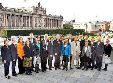Swedish Prime Minister Fredrik Reinfeldt (Centre, red tie) and members of his cabinet pose in front of the parliament building in Stockholm