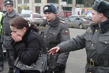 A woman cries as Interior Ministry officers block her way in front of the exit of Lubyanka metro station in Moscow