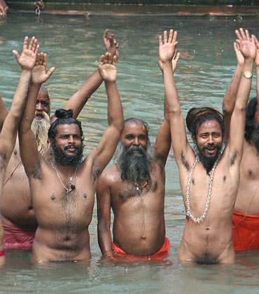 Sadhus react after taking a dip in the Ganga