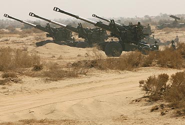 Members of Indian army's artillery take position during a joint army and air force battle exercise