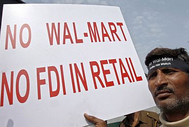 An activist from the Left parties of India holds a placard during a demonstration to protest against the entry of Wal-Mart into the Indian market, in New Delhi