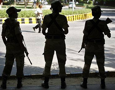 Security personnel stand guard on a road in New Delhi