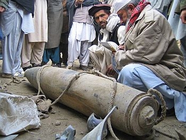 Pakistani tribesmen near an unexploded missile in a village in Zamzola area