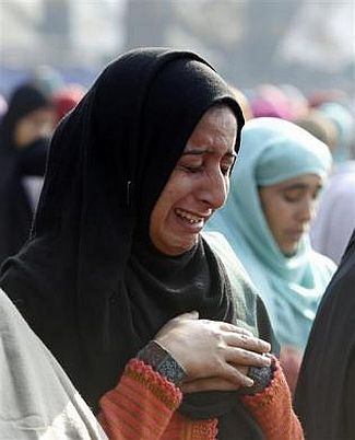 A Kashmiri woman weeps as she offers prayers during the Eid al-Adha festival in Srinagar