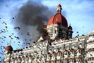Pigeons fly near the burning Taj Mahal hotel in Mumbai during the 26/11 terror attacks