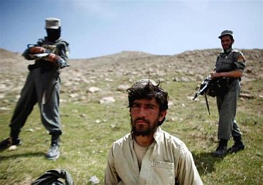 Afghan policemen with a captured Taliban fighter near the village of Shajoy in Zabol province.