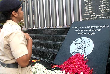 A police officers pays her respect to those who were killed in the 26/11 attacks