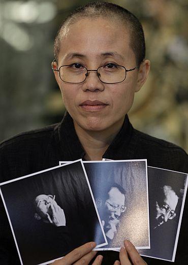 Liu Xia, the wife of Chinese dissident Liu Xiaobo, holds photos of Liu Xiaobo during an interview in Beijing on October 3