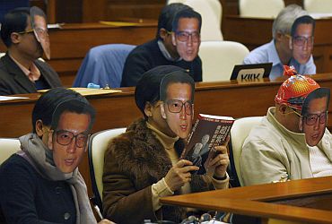 Pro-democracy lawmakers wear paper masks of jailed Chinese dissident Liu Xiaobo during a motion debate demanding his release inside the Legislative Council in Hong Kong on January 13