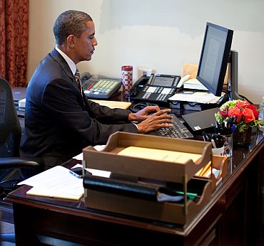 President Barack Obama does last-minute edits on his remarks at the desk of Personal Secretary Katie Johnson in the Outer Oval Office