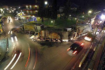 ars drive past garbage trucks burned by protesters in Terzigno