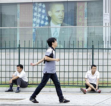 A man walks past a picture of US President Barack Obama outside the US embassy in Beijing
