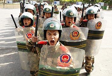 Chinese policemen take part in anti-riot training at a military base