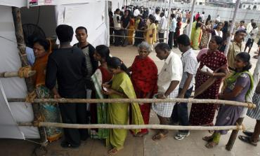 People stand in a queue to cast votes outside a polling centre in Mumbai