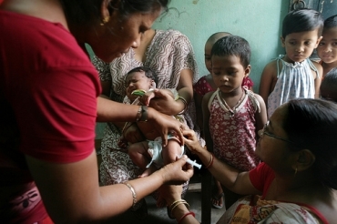 A health activist administers the Hepatitis B vaccine to a child