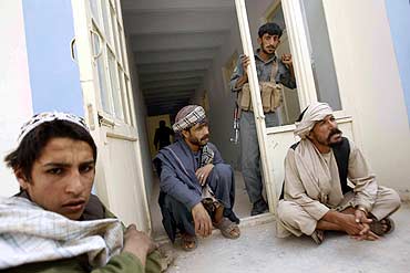 A local leader and Afghani army soldiers are seen in front of a polling station