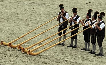 Bavarian men in traditional attire play alphorns to celebrate 200 years of Oktoberfest