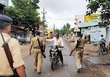 Policemen intercept a motorcyclist for venturing out during curfew, September 4