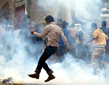 A protestor flees from the police in Kashmir