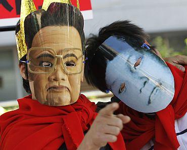 Activists wear masks depicting the North Korean leader and his son