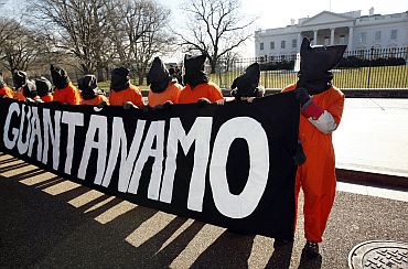 Hooded protesters dressed as Guantanamo Bay detainees demonstrate in front of the White House in Washington, DC