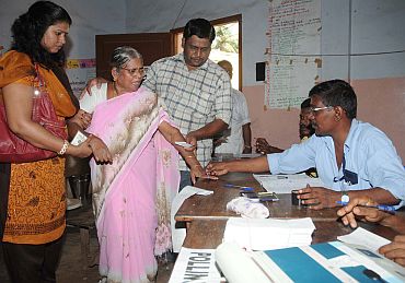 A polling officer administering indelible ink to a voter at a polling station in Thiruvananthapuram