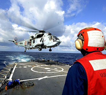 A Sailor attached to the guided-missile destroyer USS Stethem (DDG 63) watches as an Indian MK 42 Sea King helicopter prepares to land on the flight deck, as part of exercise Malabar 2011