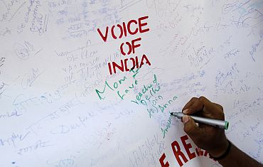 A supporter of Anna Hazare writes on a canvas during a campaign against corruption in New Delhi