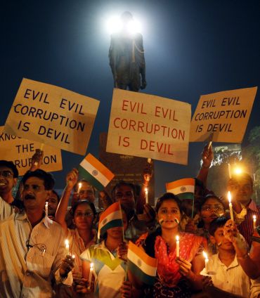 Supporters of social activist Hazare hold placards during a candlelight campaign against corruption in Ahmedabad