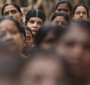 Devotees stand in a queue to pay their last respects to the spiritual guru Sri Sathya Sai Baba