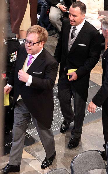 British singer Elton John (L), and his partner David Furnish, arrive at Westminster Abbey