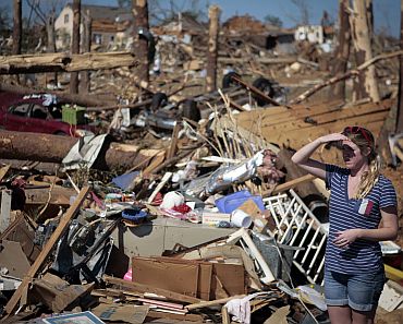 A woman looks over devastation in the aftermath of deadly tornados in Tuscaloosa, Alabama