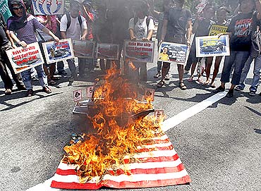 Protesters burn a replica of the US flag outside the US embassy
