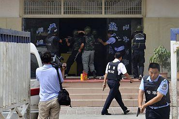 Armed Chinese policemen trying to rescue hostages at a police station during a clash at Hotan in Xinjiang Uygur Autonomous Region.