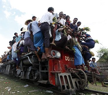 People try to board a crowded passenger train to take part in the Nat, or spirits, festival, at Taungbyone station, near Mandalay, Myanmar