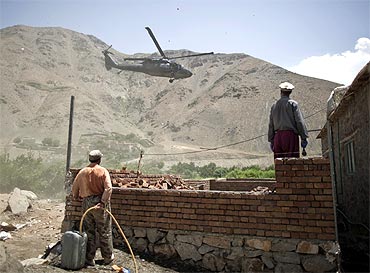 Afghans watch as a US Chinook helicopter leaves after a security handover ceremony in Panjshir province